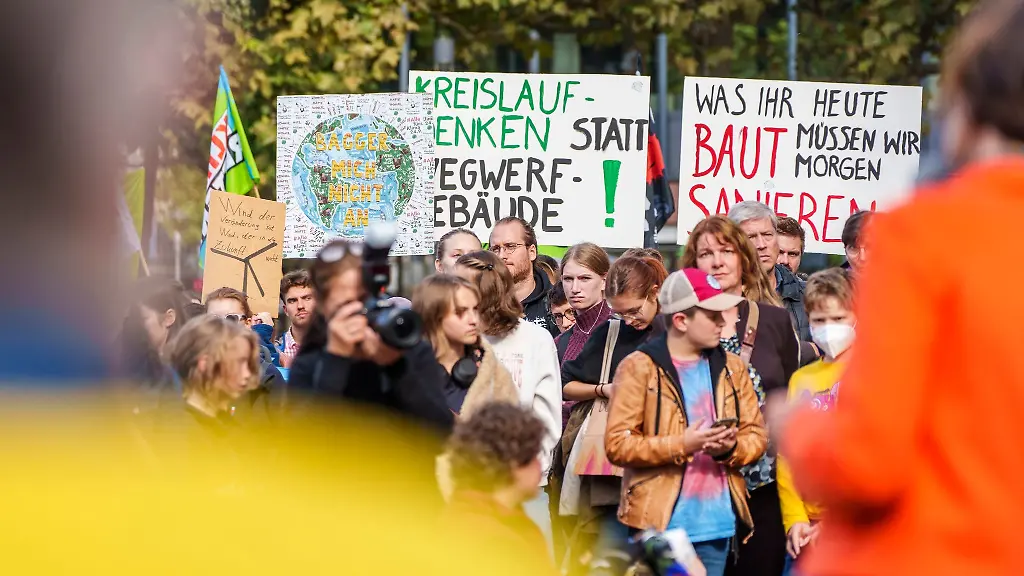 Die-Kundgebungsteilnehmer-stehen-mit-Bannern-auf-dem-Schillerlatz-in-Mainz