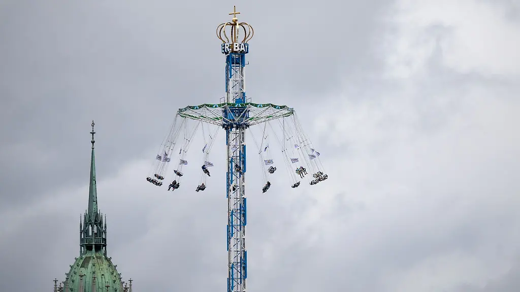 Wiesnbesucher-fahren-auf-dem-Oktoberfest-mit-einem-Kettenkarussell