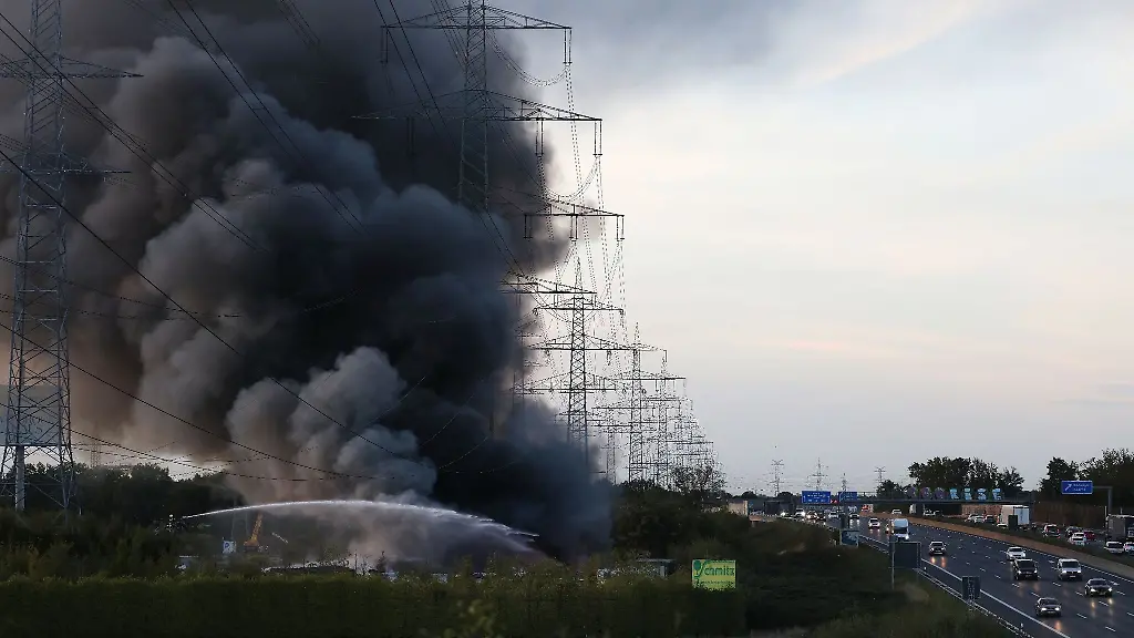 Eine-grosse-Rauchsaeule-steigt-neben-der-Autobahn-A57-bei-einem-Brand-auf-einem-Schrottplatz-auf