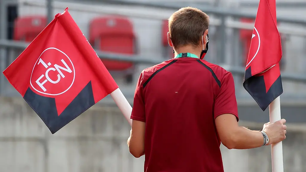Ein-Stadion-Mitarbeiter-traegt-eine-Eckfahnen-mit-dem-Logo-des-1-FCN
