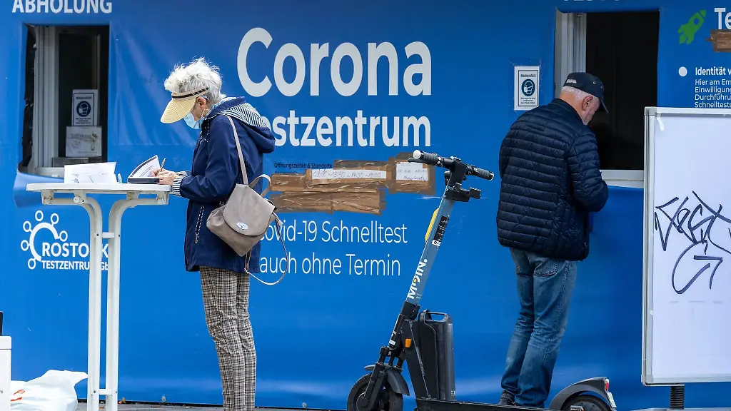 Passanten-stehen-vor-einem-Corona-Testzentrum-auf-dem-Marktplatz-von-Warnemuende