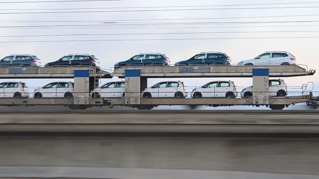 Ein-Gueterzug-mit-Neuwagen-faehrt-ueber-eine-Bruecke