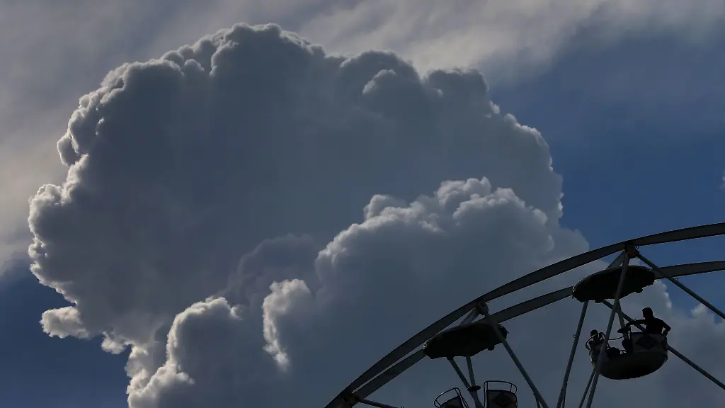 Wolken-tuermen-sich-hinter-dem-Riesenrad-einer-Kirmes