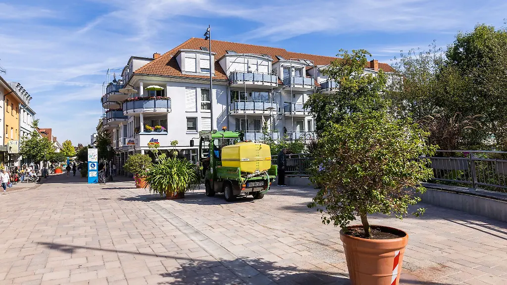 Eine-Frau-in-einem-Nutzfahrzeug-giesst-eine-Topfpflanze-auf-der-Bernhardusbruecke-in-Bad-Krozingen