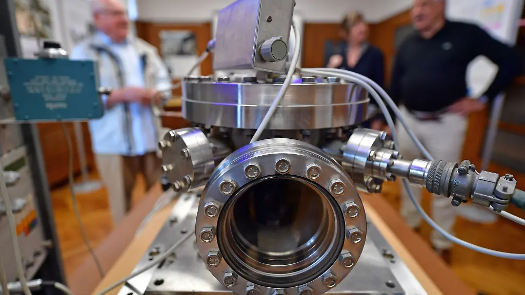 Artur-Kamp-l-r-Angela-Birk-und-Willi-Birk-sprechen-miteinander-neben-dem-Original-der-in-der-DDR-gebauten-Caesium-Atomuhr-im-Ruhlaer-Uhrenmuseum