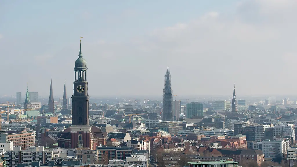 Der-Michel-l-das-Wahrzeichen-Hamburgs-und-weitere-Kirchtuerme-sind-ueber-den-Daechern-der-Hansestadt-zu-sehen