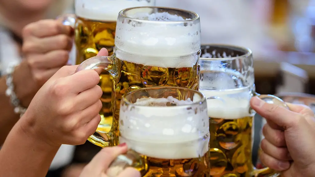 Besucher-stossen-auf-dem-Oktoberfest-mit-Bier-an