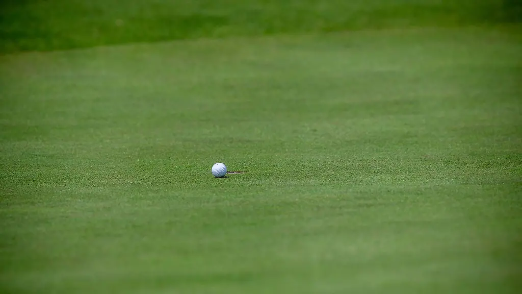 Ein-Golfball-liegt-wenige-Zentimeter-vor-dem-Loch