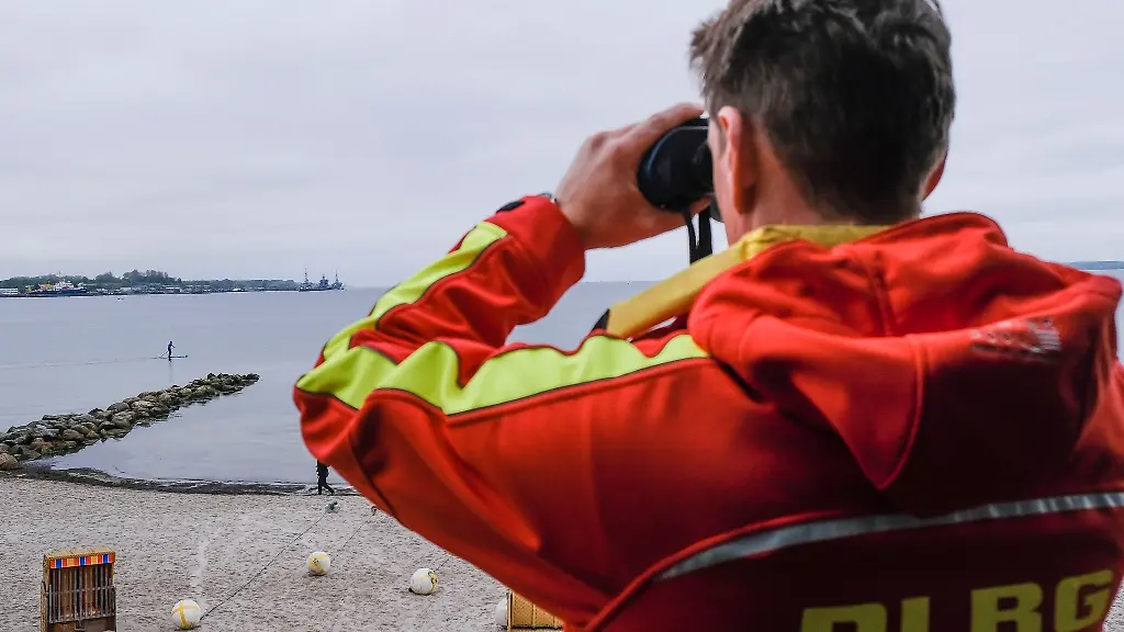 Ein-DLRG-Mitarbeiter-schaut-durch-ein-Fernglas