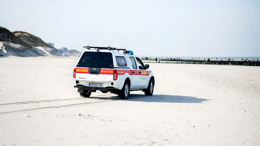 Ein-Einsatzfahrzeug-der-DLRG-Wasserrettung-faehrt-ueber-einen-Strand