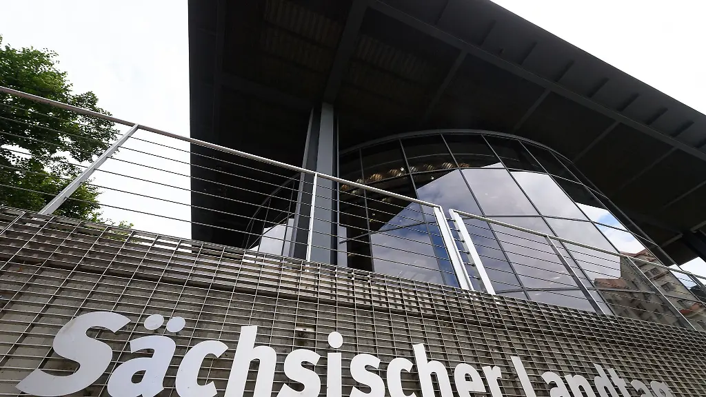 Saechsischer-Landtag-steht-an-einem-Gitter-am-hinteren-Teil-des-Parlamentsgebaeudes