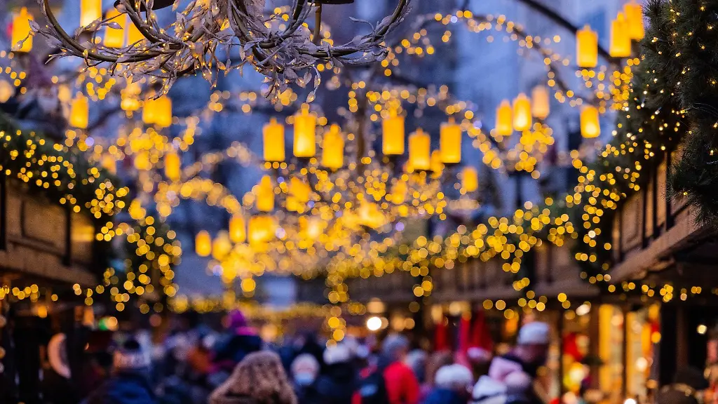 Besucher-gehen-ueber-einen-Weihnachtsmarkt