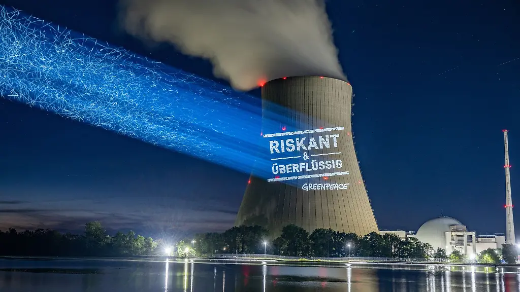 Greenpeace-Aktivisten-projizieren-Riskant-ueberfluessig-an-den-Kuehlturm-am-Kernkraftwerk-Isar-2