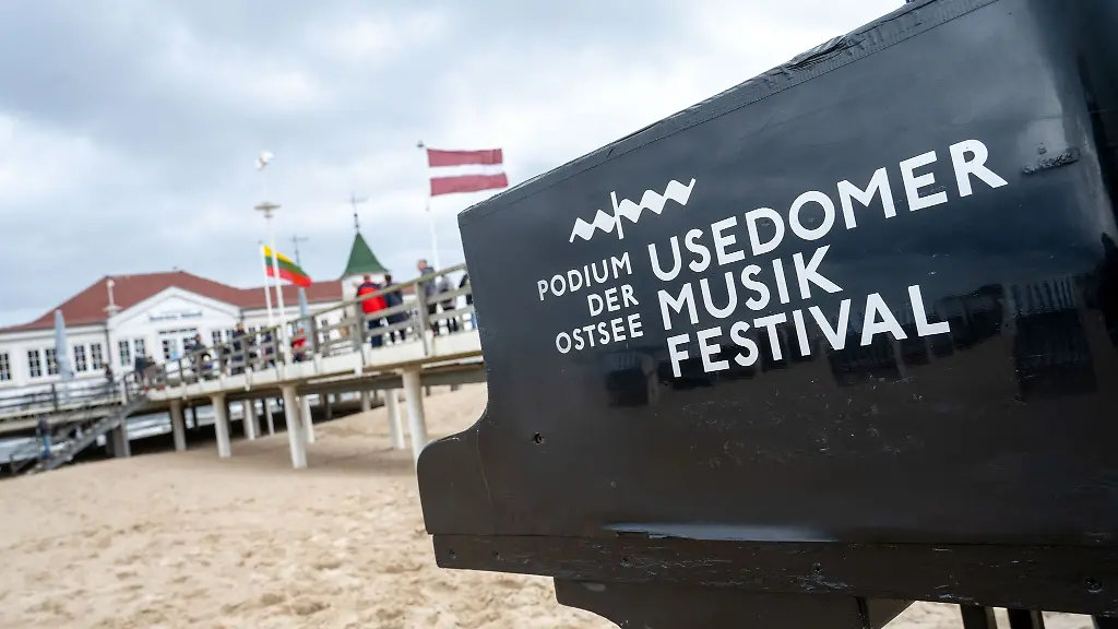 Ein-Klavier-Fluegel-mit-dem-Logo-des-Usedomer-Musikfestivals-steht-am-Strand-der-Insel-Usedom
