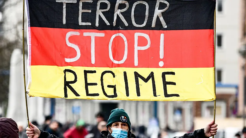 Ein-Teilnehmer-haelt-eine-Deutschland-Fahne-mit-Schriftzug-bei-einer-Demonstration-gegen-die-Corona-Politik