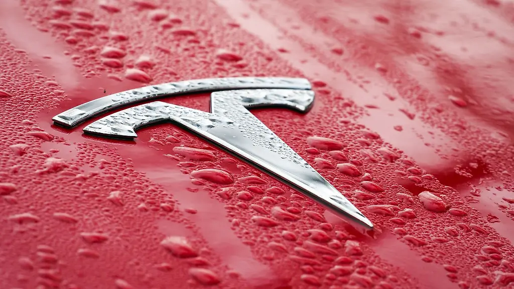 Das-Logo-auf-der-nassen-Motorhaube-eines-roten-Tesla