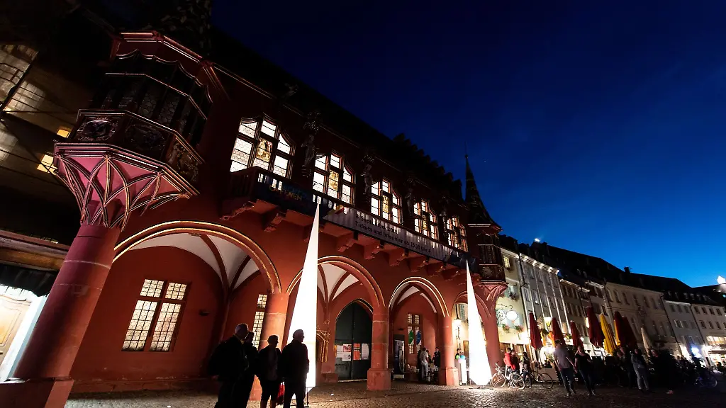 Menschen-stehen-waehrend-der-Nacht-des-offenen-Denkmals-vor-dem-historischen-Kaufhaus-in-Freiburg
