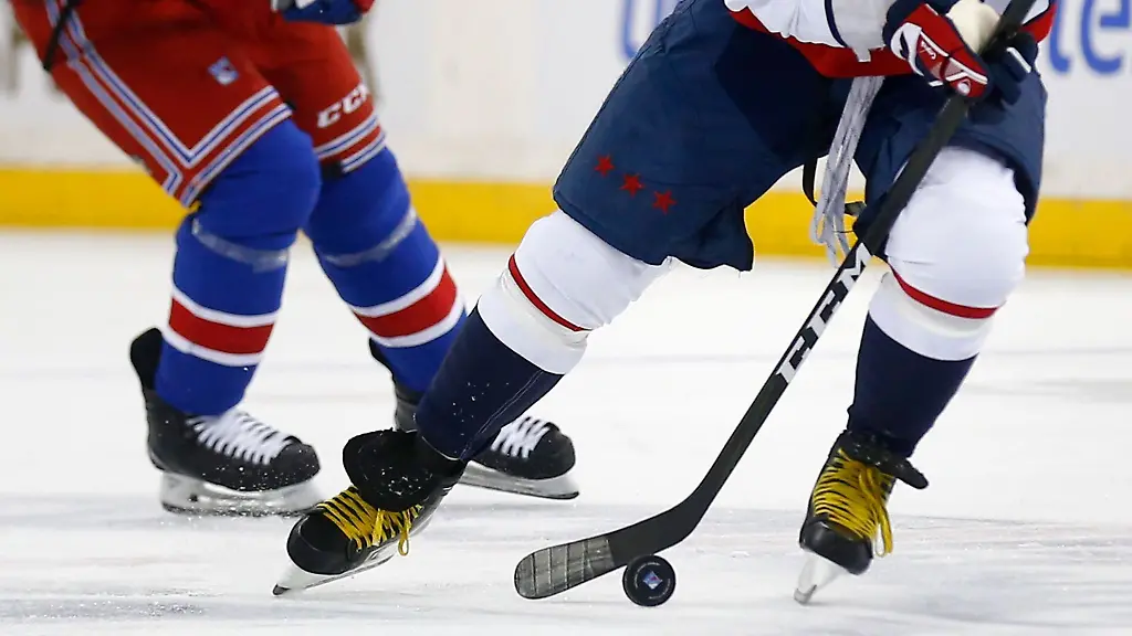 Zwei-Eishockeyspieler-kaempfen-um-den-Puck