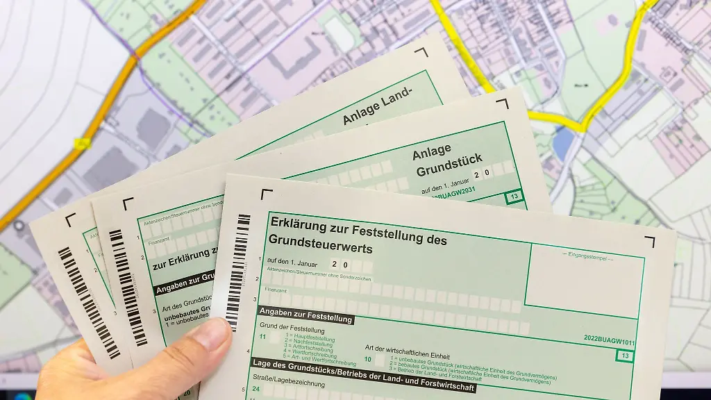 Eine-Mitarbeiterin-haelt-im-Finanzamt-Formulare-zur-Grundsteuererklaerung-in-der-Hand