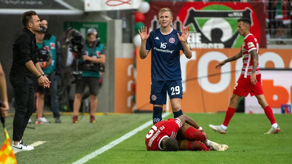Augsburgs-Felix-Uduokhai-v-liegt-nach-einem-Foul-auf-dem-Rasen