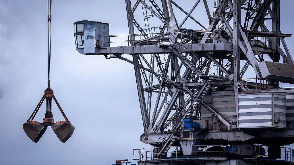 Blick-auf-einen-stillstehenden-Hafenkran-vor-dem-Kuehlturm-des-Steinkohlekraftwerks