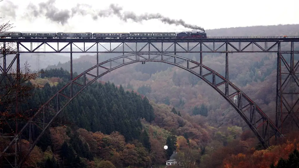 Ein-von-einer-Dampflok-gezogener-Zug-faehrt-bei-einem-Brueckenfest-ueber-die-Muengstener-Bruecke