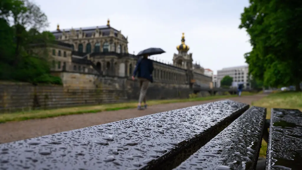 Eine-Bank-vor-dem-Dresdner-Zwinger-mit-dem-Kronentor-ist-mit-Regentropfen-benetzt