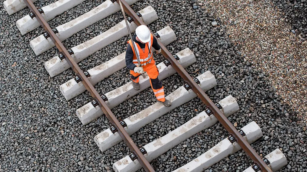 Ein-Arbeiter-geht-ueber-eine-noch-nicht-fertige-Gleisanlage-der-Bahn