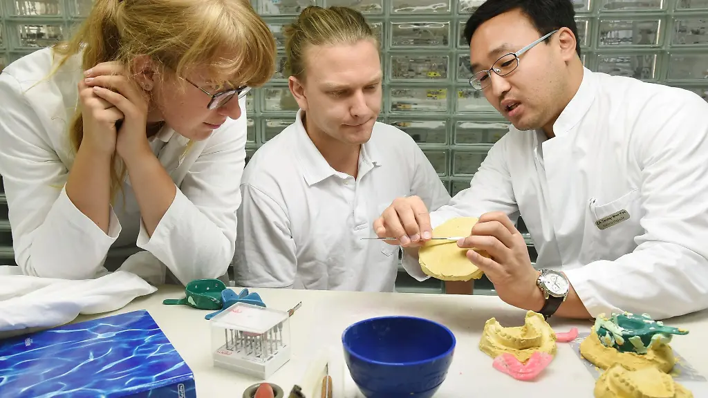 Studierende-der-Zahnmedizin-ueberpruefen-in-einem-Uebungssaal-mit-einem-Zahnarzt-r-die-Abformung-eines-Kiefers