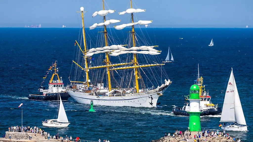 Die-Gorch-Fock-faehrt-auf-der-Ostsee-mit-Hafenschleppern-in-den-Seekanal-in-Warnemuende