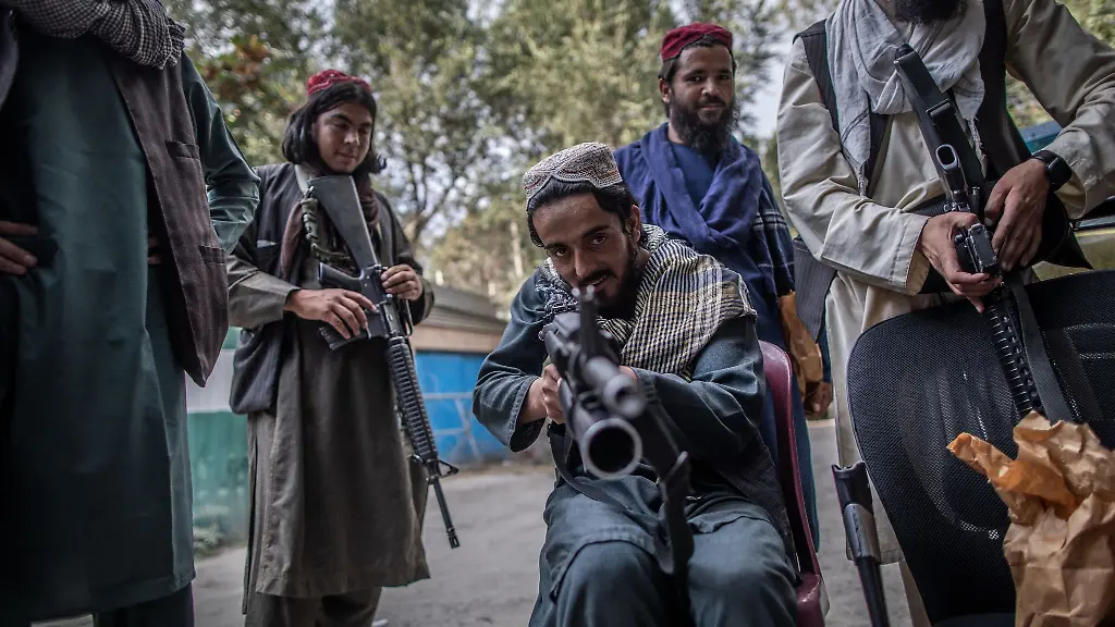 Ein-junger-Taliban-Kaempfer-zielt-zum-Spass-mit-seinem-Gewehr-in-Richtung-Fotograf-waehrend-er-vor-einer-Polizeistation-in-Kabul-Wache-haelt