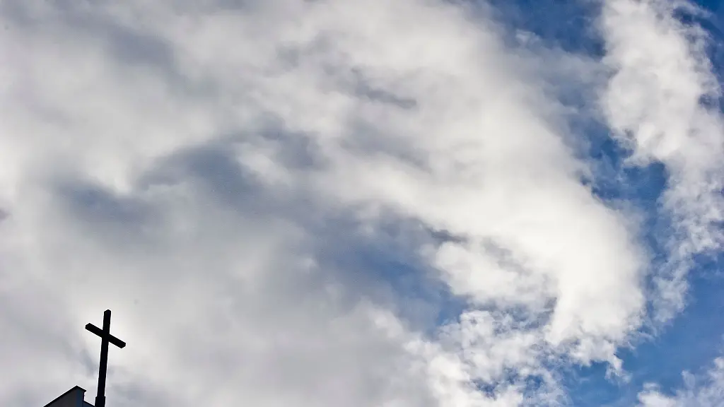 Ein-Kreuz-ist-vor-bewoelktem-Himmel-zu-sehen