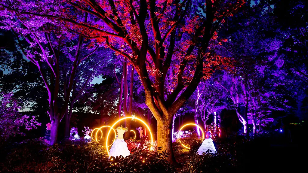 Zahlreiche-Figuren-und-leuchtende-Ringe-stehen-im-Park-der-Gaerten-in-einem-Beet