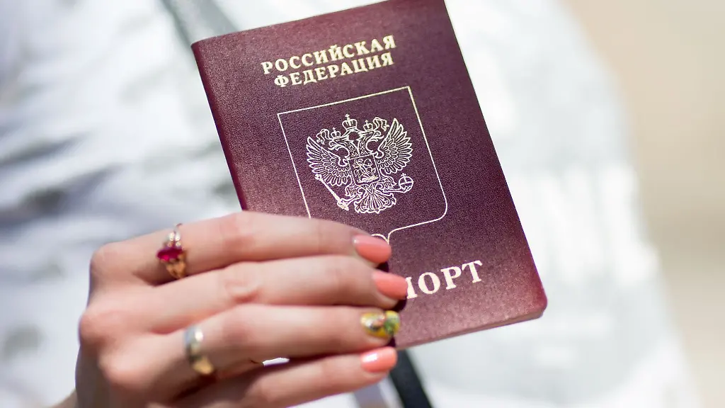 Eine-Russin-zeigt-ihren-Reisepass-Estland-hat-als-eine-Reaktion-auf-Russlands-Angriffskrieg-die-Vergabe-von-Visa-und-Aufenthaltsgenehmigungen-an-Russen-ausgesetzt