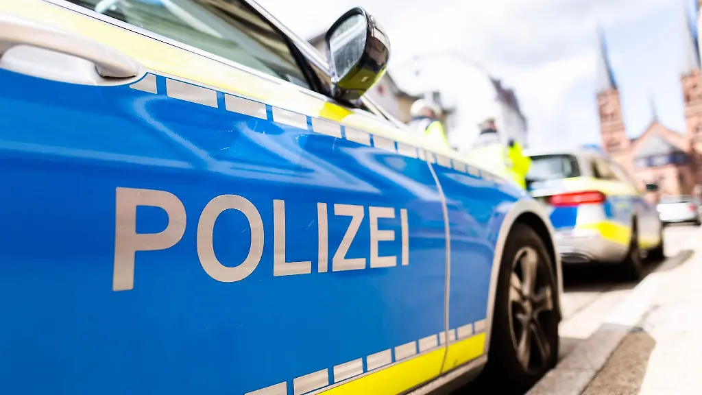 Zwei-Streifenwagen-der-Polizei-stehen-am-Strassenrand
