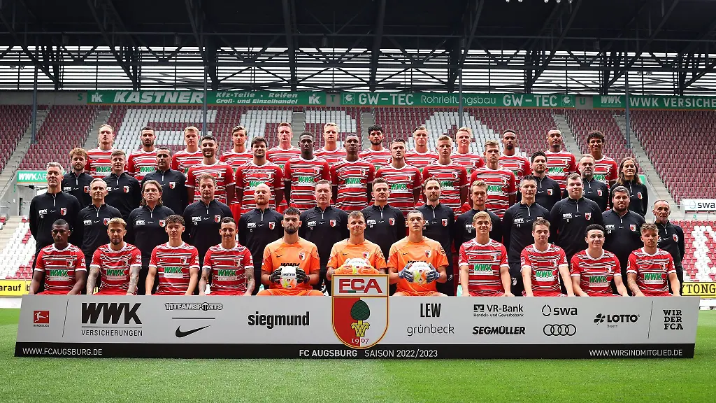 Spieler-und-Offizielle-stehen-beim-Mannschaftsfototermin-des-FC-Augsburg-in-der-WWK-Arena-zusammen