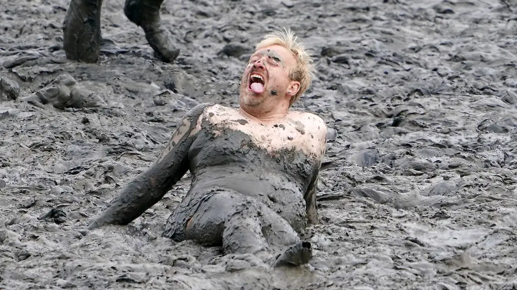 Erschoepft-liegt-ein-Teilnehmer-des-Fussballturniers-waehrend-der-14-Wattoluempiade-am-Elbdeich-Brunsbuettel-im-Schlick