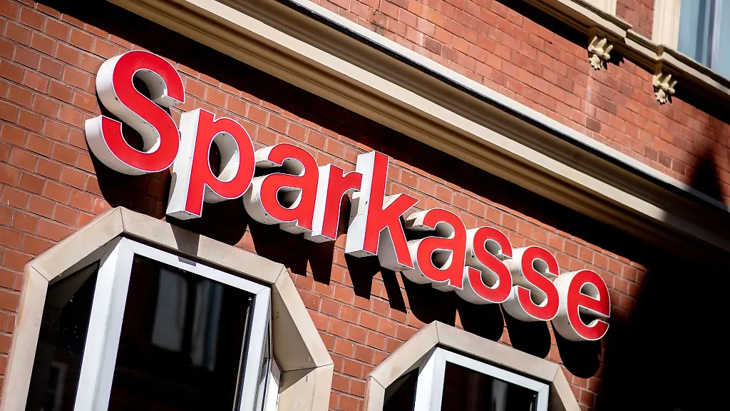Der-Schriftzug-der-Sparkasse-haengt-in-der-Innenstadt-an-einer-Filiale
