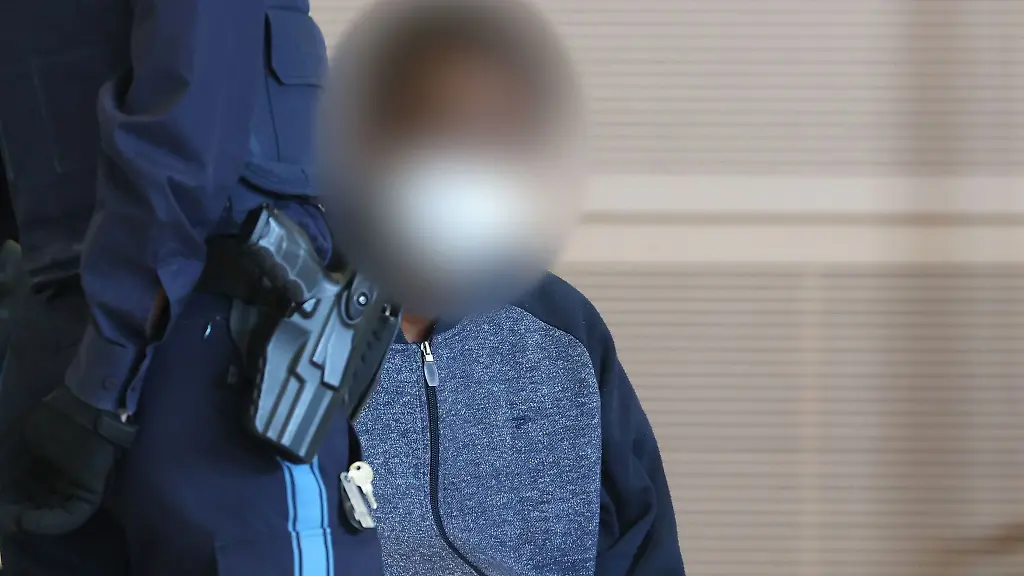 Der-Beschuldigte-sitzt-in-einem-Gerichtssaal-auf-der-Anklagebank