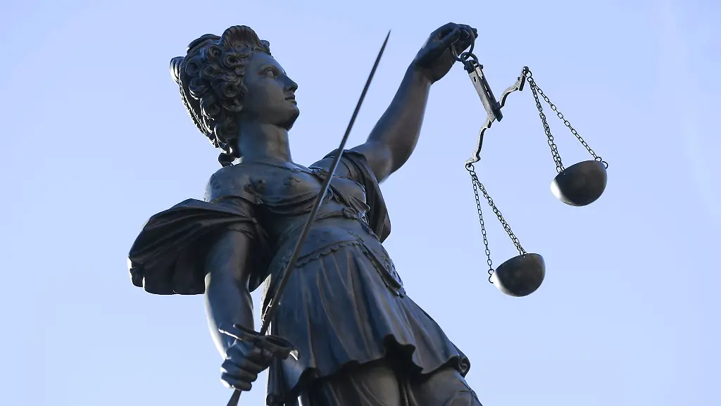 Eine-Statue-der-Justitia-steht-unter-freiem-Himmel