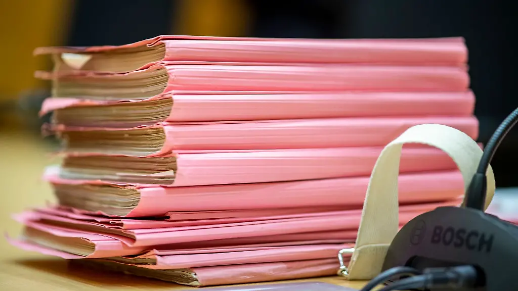 Ein-Aktenstapel-liegt-in-einem-Gerichtssaal-auf-dem-Richtertisch