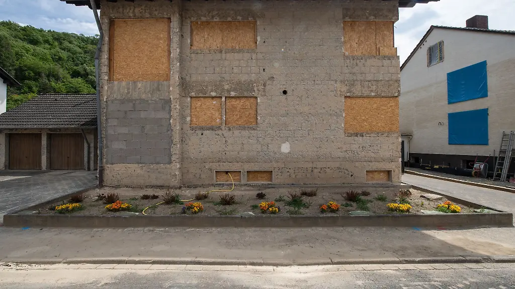 Mit-Spanplatten-notduerftig-abgedichtet-sind-die-Fenster-eines-bei-der-Flut-massiv-beschaedigten-Hauses