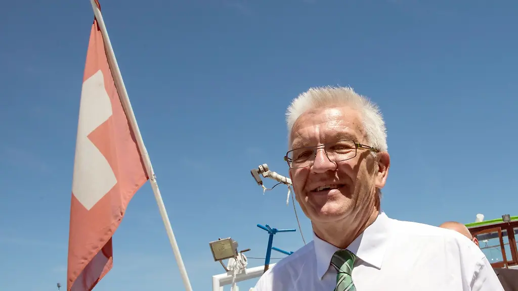 Baden-Wuerttembergs-Ministerpraesident-Winfried-Kretschmann-Gruene-neben-einer-Schweizer-Fahne