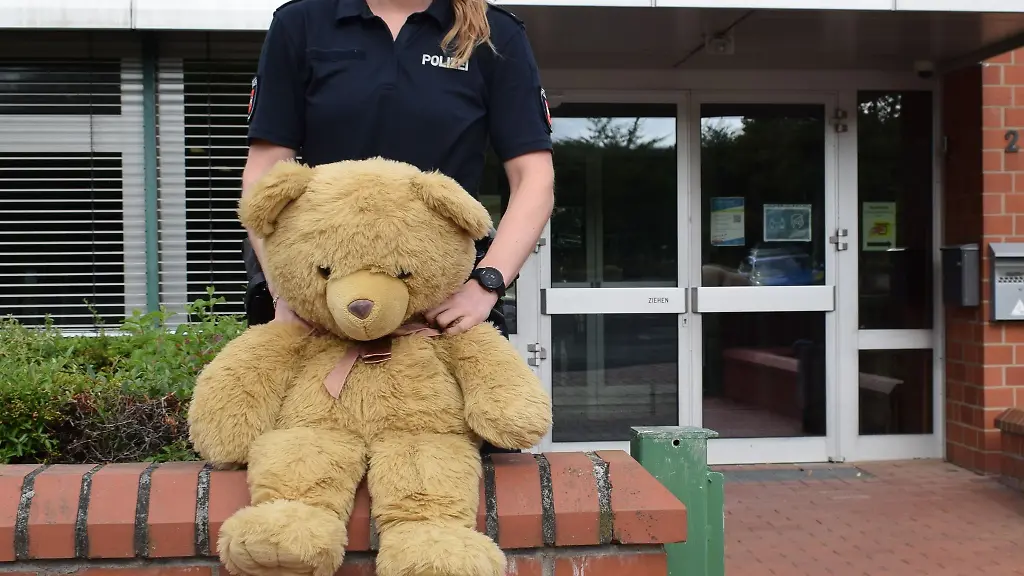 Die-Polizeibeamtin-Paulina-steht-mit-Teddy-vor-dem-Dienstgebaeude-in-der-Otto-Hahn-Strasse