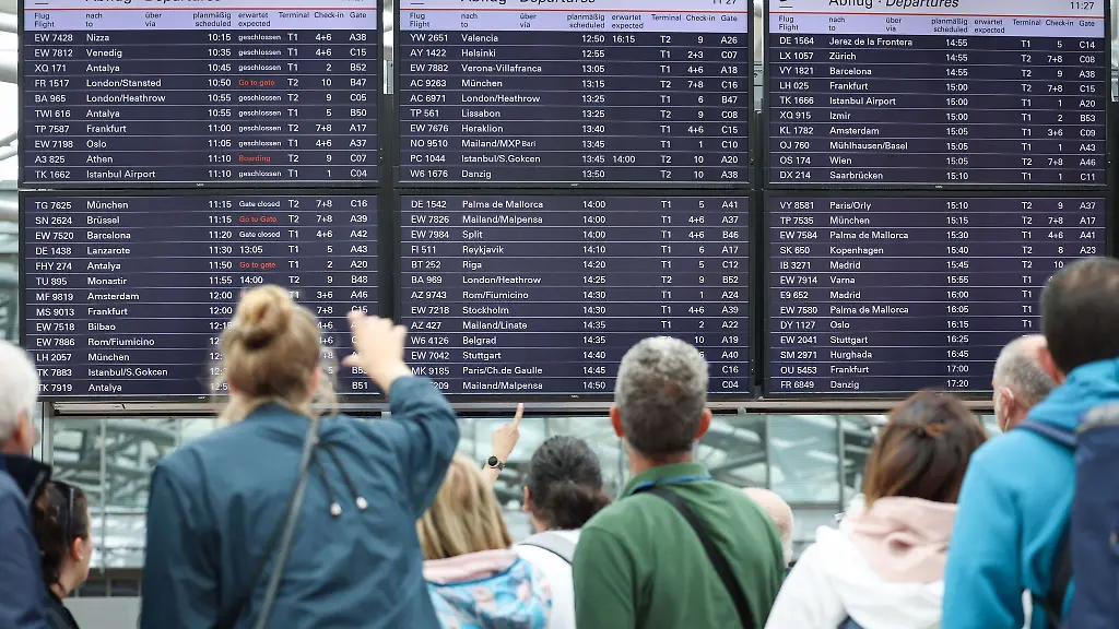Passagiere-stehen-vor-den-Anzeigetafeln-von-Terminal-1-des-Hamburger-Flughafens