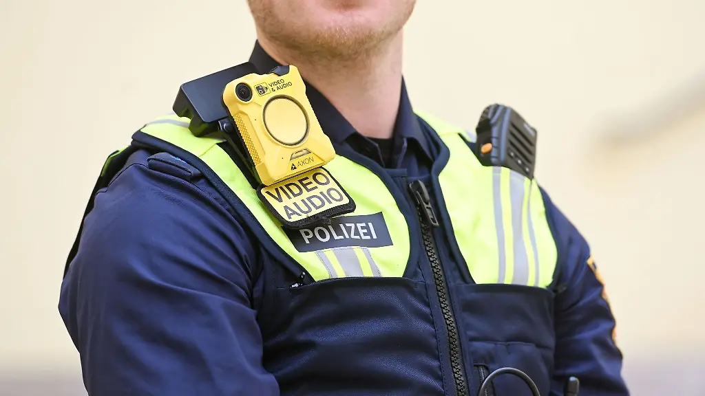 Ein-Polizeibeamter-traegt-eine-Bodycam-und-eine-SK1-Schutzweste-aufgenommen-bei-einer-Pressekonferenz