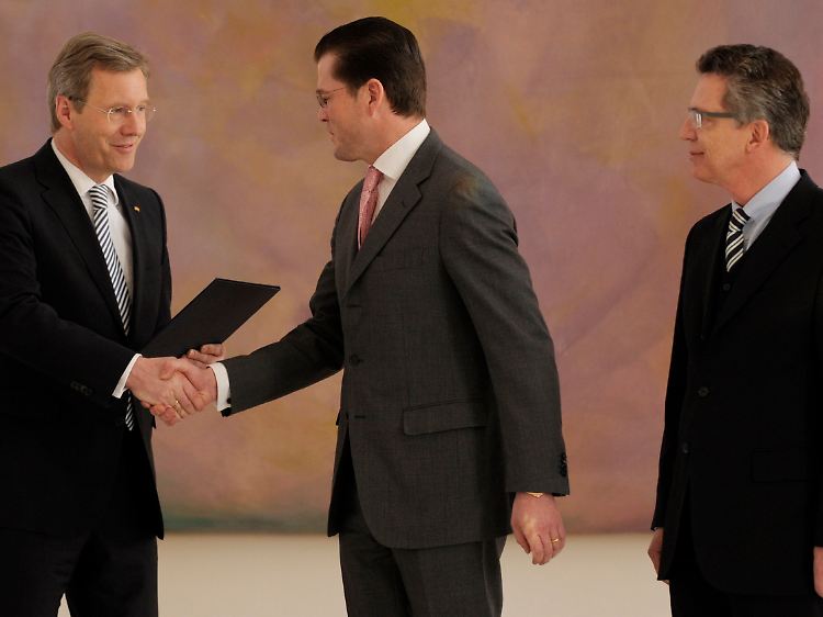 Auf Wiedersehen? Bundespräsident Wulff dankt Guttenberg für seine Dienste. Nachfolger de Maizière schaut zu.