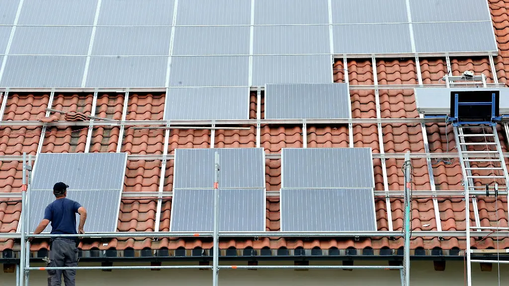 Ein-Arbeiter-installiert-auf-einem-Dach-eine-Solaranlage