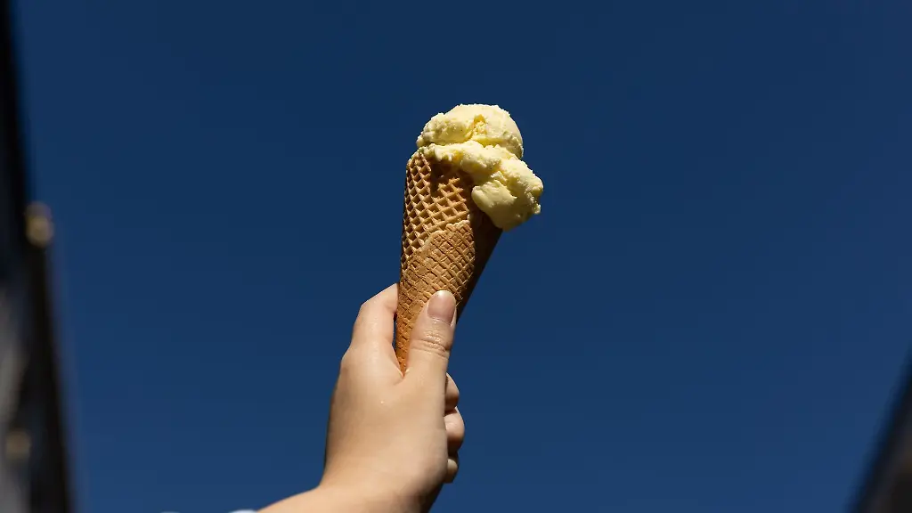 Ein-Speiseeis-wird-in-Bielefeld-vor-den-blauen-Himmel-gehalten