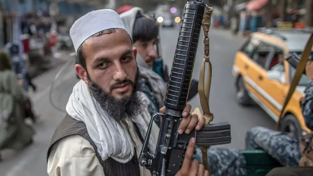 Junge-Taliban-Kaempfer-patrouillieren-auf-der-Ladeflaeche-eines-Pick-Ups-in-den-Strassen-von-Kabul